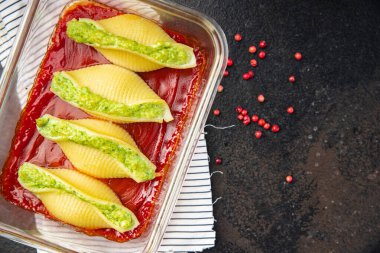 makarna sosu ıspanak peyniri doldurulmuş konchiglie doldurulmuş sağlıklı yemek abur cuburu fotokopi masasının arka planında 
