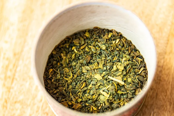 緑茶乾燥花弁風味のお茶は熱い飲み物を準備するために振りかけ新鮮な部分健康的な食事食事食事療法テーブルの上にスナックコピースペースフード背景素朴なトップビュー — ストック写真