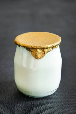 Doğal yoğurt kavanozu. Sağlıklı beslenme yiyeceği. Fotokopi masasında.