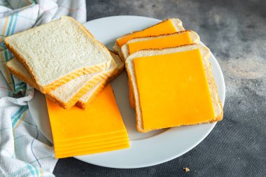 Peynirli sandviç çedar ya da mimolette peyniri. Masada taze sağlıklı yemek atıştırmalığı diyeti. Arka plandaki yiyeceklerin fotokopisi.