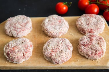 Pirzola kıyma, sığır eti, kuzu eti, tavuk ekmek kırıntısı pirzola. Masada atıştırmalık şeyler var. 