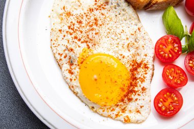 Kızarmış yumurta, domates, kahvaltılık sağlıklı yemek atıştırmalığı diyeti fotokopi masasında. Arka plan kırsal yemek manzarası.