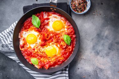 Shakshuka yumurtaları, domates, biber, sebze kahvaltıda sağlıklı yemek atıştırmalıkları diyeti masada fotokopi uzayı arka plan kırsal manzarası