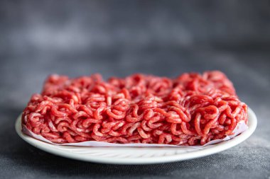 Fotokopi masasında taze kıyma, çiğ domuz eti, biftek ve atıştırmalık şeyler var.