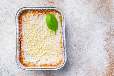 Tek kullanımlık alüminyum konteynırda lazanya. Lezzetli atıştırmalıklar. Yemek atıştırmalığı diyeti. 