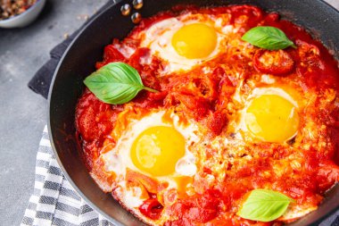 Yumurtalı omlet, Shakshuka kahvaltı yumurtaları, sebze, yemek atıştırmalıkları, fotokopi masasının arkasında. 