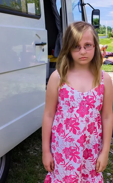 Ragazza con la faccia acida sullo sfondo del bus e il verde — Foto Stock