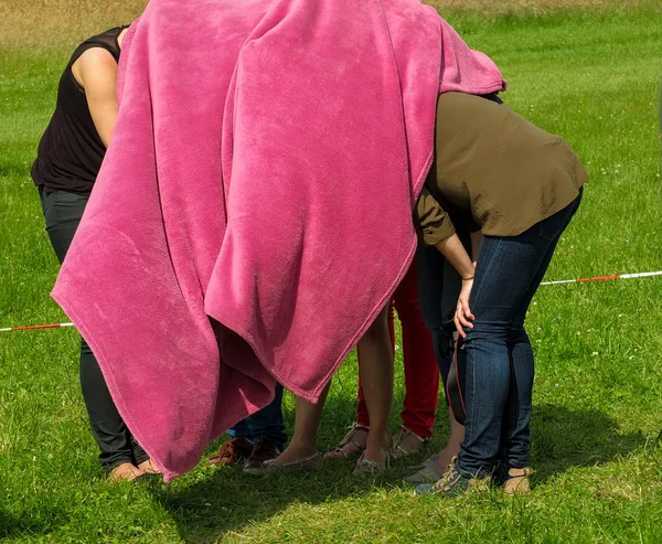Crowd women under  pink blanket hiding  nature — Stock Photo, Image