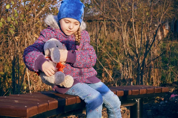 Девочка Сидит Скамейке Парке Обнимает Плюшевого Кролика Место Прогулок Отдыха — стоковое фото