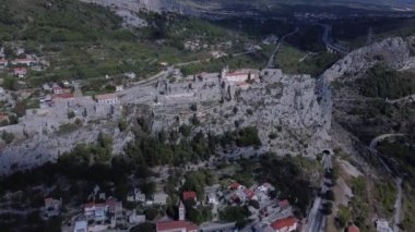 Hırvatistan 'ın Split kenti yakınlarındaki bir kalede insansız hava aracı uçuşu. Kalenin kuş bakışı görüntüsü. Dağ Manzarası. Yüzlerce yıllık kalenin zengin, çok yönlü bir tarihi var. Geniş manzaralı bir tepeye tünemiş. Klis Kalesi, Bölünme, Hırvatistan