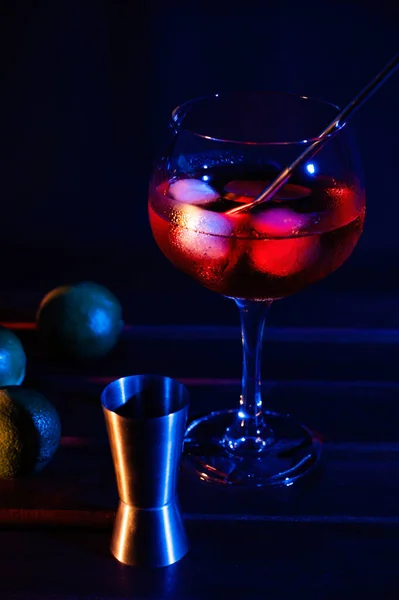 Red cocktail glass with limes and colored lights