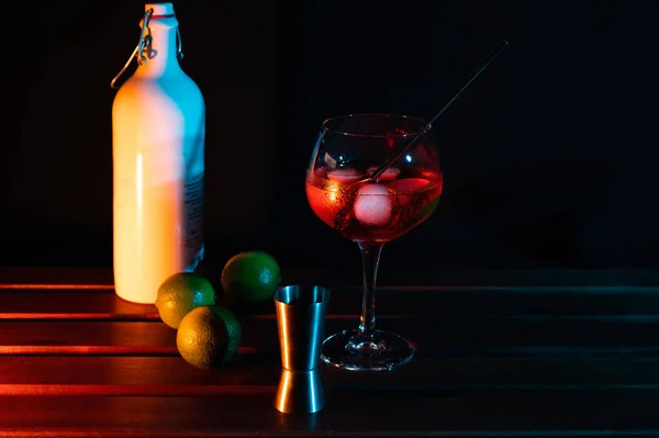 Red cocktail glass with limes and colored lights