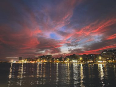 Mobile photography of touristic destination Torrevieja, Spain. Nature urban landscape with pleasure port with harbor, sea and beach. Gorgeous red sky at sunset with beautiful sky clouds. 
