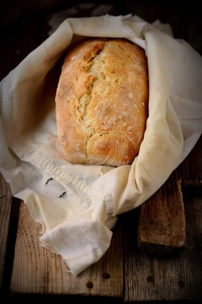 Świeży chleb domowej roboty na drewnianym stole — Zdjęcie stockowe