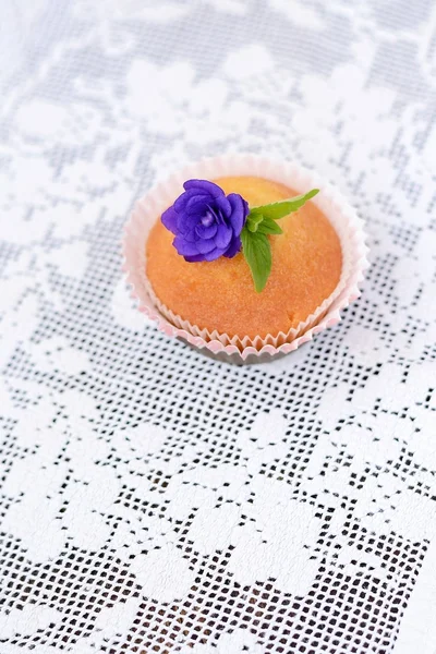 Cupcake on a white lace tablecloth — Stock Photo, Image