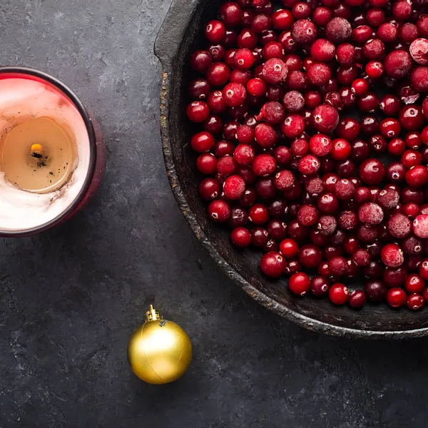 Ingredientes de vino caliente de Navidad. Lingonberry, arándano, bayas rojas, anís, canela, naranja sobre un fondo oscuro. Imagen de unas acogedoras vacaciones en casa. Vista superior. — Foto de Stock