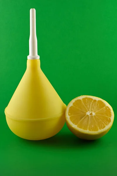 Clistere medico con limone su verde — Foto Stock