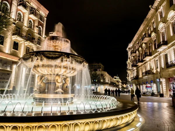 Baku, Azerbajdzjan - 22 november: fontän i slutet av nizami gatan i baku, Västazarbaijan, upplyst av natten på den 22 november 2013. gatan är känd för sina exklusiva butiker — Stockfoto