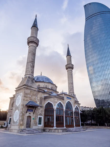 BAKU, AZERBAIJAN - NOVEMBER 22, 2013: Sehidler Mescidi Mosque next to the Flame Towers in Baku, Azerbaijan. Flame Towers are the first flame-shaped skyscrapers in the world. — Stock Photo, Image