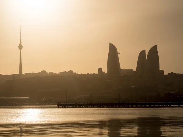 BAKU, AZERBAIJAN - NOVEMBER 22, 2013: Flame Towers in Baku at sunset. Flame Towers are the first flame-shaped skyscrapers in the world and they can be seen from almost any point of the city — Stock Photo, Image