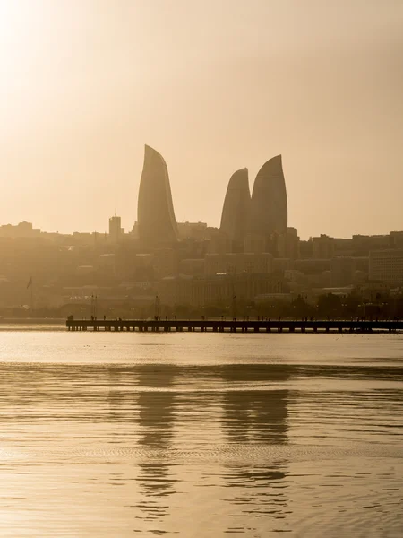 BAKU, AZERBAIJAN - NOVEMBER 22, 2013: Flame Towers in Baku at sunset. Flame Towers are the first flame-shaped skyscrapers in the world and they can be seen from almost any point of the city — Stock Photo, Image