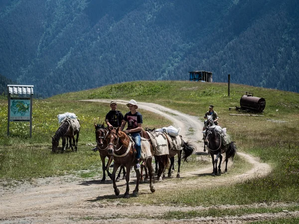 OMALO, GEORGIA - July 08, 2013: Local people riding horses in Lower Omalo (Kvemo Omalo) on a summer day. In Tusheti horse is still a popular mean of transport. Omalo is the capital of Tusheti region — Stock Photo, Image