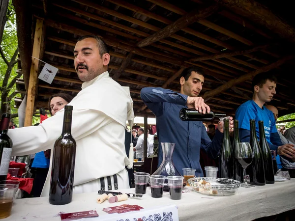 ТБИЛИСИ, Грузия - 11 мая: Ежегодный фестиваль молодого вина в Этнографическом музее в Тбилиси 11 мая 2013 года. Посетители дегустируют вино, представленное крупными производителями и частными лицами, которые его производят. — стоковое фото
