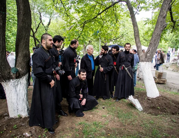 TBILISI, GEORGIA - 11 DE MAYO: Hombres con ropa tradicional cantan canciones georgianas durante el festival anual de vinos jóvenes en el Museo Etnográfico de Tiflis el 11 de mayo de 2013 — Foto de Stock