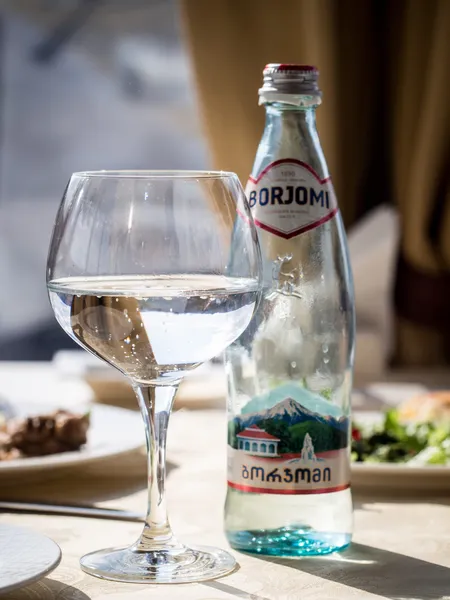 Botella y vidrio Borjomi — Foto de Stock