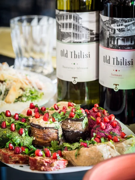 Saperavi, vino tinto seco georgiano y vino blanco seco en la mesa con comida — Foto de Stock