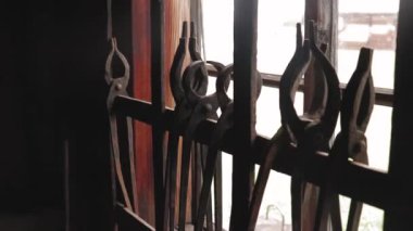 Demir tabaklar, pense, demirci, pencerenin dışında bir gün, metal pencere ızgarası, geriye doğru pürüzsüz kamera kalkışı.