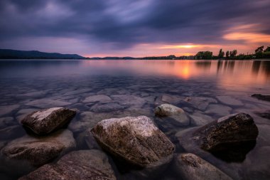 Constance Gölü 'nün renkleri. Suyun altında güzel bulutlar ve taşlar var.
