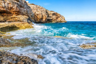 Dalgalar ve güzel deniz manzaralı Cala Anguila Körfezi