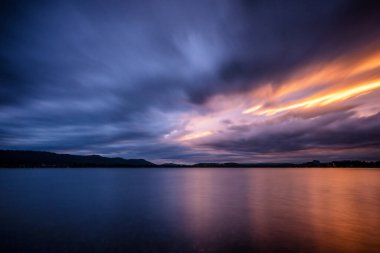 Gökyüzünde mor bulutlar olan güzel Constance Gölü 'nde güçlü bir günbatımı yaz zamanı