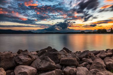 Lake Constance sunset with colorful clouds and stones on the shore