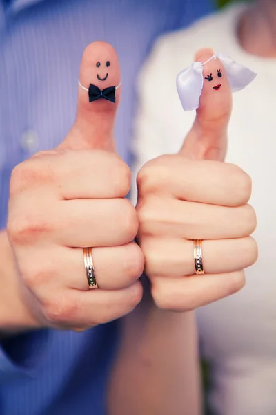 Prsteny na ruce oblečený jako ženich a nevěsta — Stock fotografie