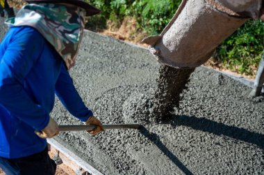 İnşaat şantiyesinde ticari beton döşeme sırasında beton dökülüyor. İnşaat mühendisi. 