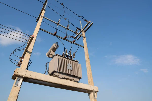 Electricity, Large high voltage transformer It is installed on strong concrete poles to supply electricity to the buildings for the community with the background of the sky.
