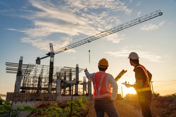 建設現場の建設プロジェクトの進捗状況を監督するアジアの2人のビジネスマン建設技術者 — ストック写真