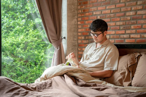 Evdeki yatak odasında kitap okuyan bir adam.. 