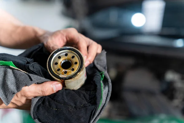 Auto mechanic is checking the oil filter of the car in Car repair station