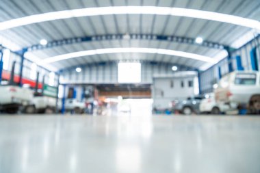 Otomotiv endüstrisinin bulanık arka planı, araba tamir servisi araba fabrikasının epoksi katı, büyük endüstriyel bir binanın içi veya çelik yapıları olan bir fabrikanın içi. Çelik çatı çerçevesi.