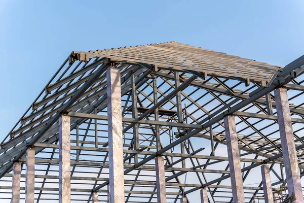 Roof structure of steel for building or house construction on sky background.