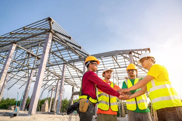 建築家とエンジニアの建設労働者は屋外建設現場で作業しながら手を携えています 建設協力の概念を構築する チームワークのコンセプト — ストック写真