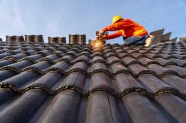 İnşaat işçisi yeni çatı döşemesi, beton çatı döşemeleri ve çatı aletleriyle yeni çatılarda kullanılan elektrikli matkap. Beton Çatı Döşemeleri Seçici odak