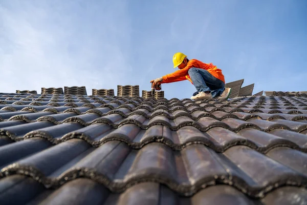 İnşaat işçisi yeni çatı döşemesi, beton çatı döşemeleri ve çatılarda kullanılan elektrikli matkap..