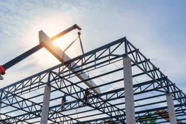 Teamwork of roofers with crane is lifting the PU foam roof sheet on the steel roof structure at the construction site. Install a new roof.