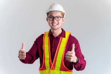 Asyalı mühendisin portresi. Stüdyoda baş parmağıyla poz veriyor. İnşaat Mimarı, Mühendisi, İnşaat Konsepti.