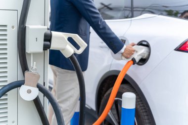 Şarj kablosunun odak noktasını seçin. Şehirdeki aküye ek şarj için elektrikli arabaya güç kaynağı bağlanıyor. Yeşil enerji kavramı ve CO2 salınımını azaltmak. EV arabası. 