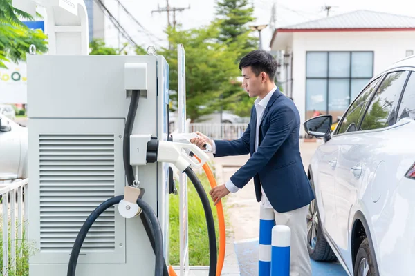 Aziatische Man Met Auto Elektrisch Voertuig Laadstation Met Stroomkabel Aangesloten — Stockfoto